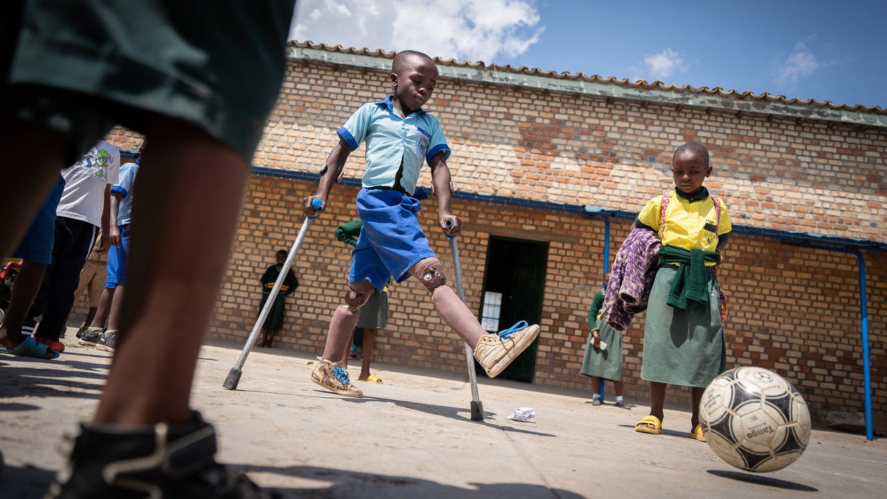 Longini, ici jouant au football dans la cour de l'école après avoir reçu ses nouvelles prothèses.