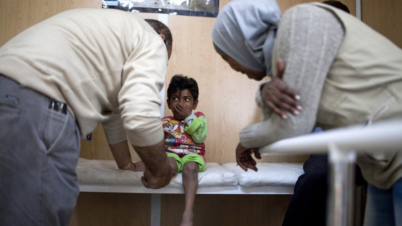 Un kinésithérapeute de Handicap International examine Qasem, fillette syrienne de 10 ans atteinte de nanisme.