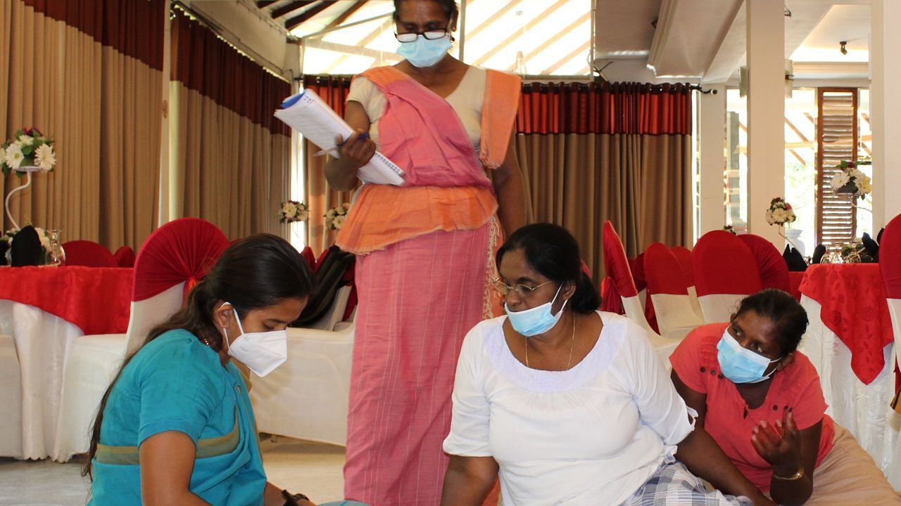 HI Sri Lanka 4 femmes, dont une mobilisatrice communautaires de HI sont assises, dans une salle et discutent ensemble