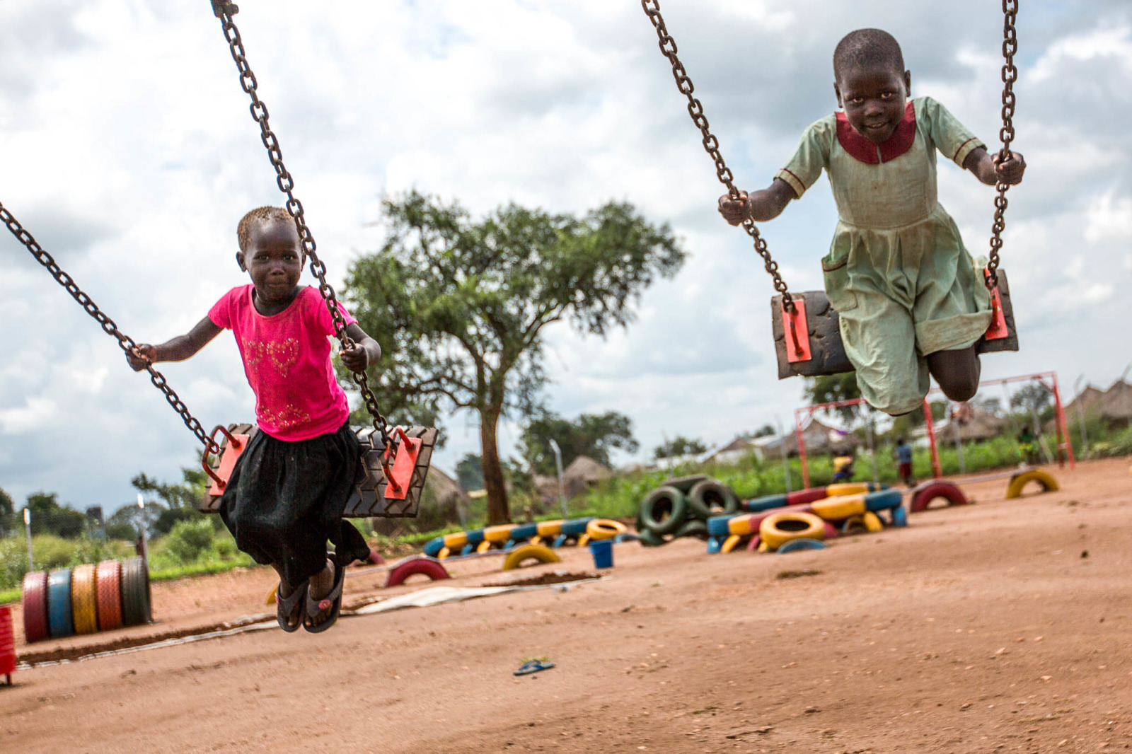 Des enfants jouent sur les balançoires dans le camp Omugo
